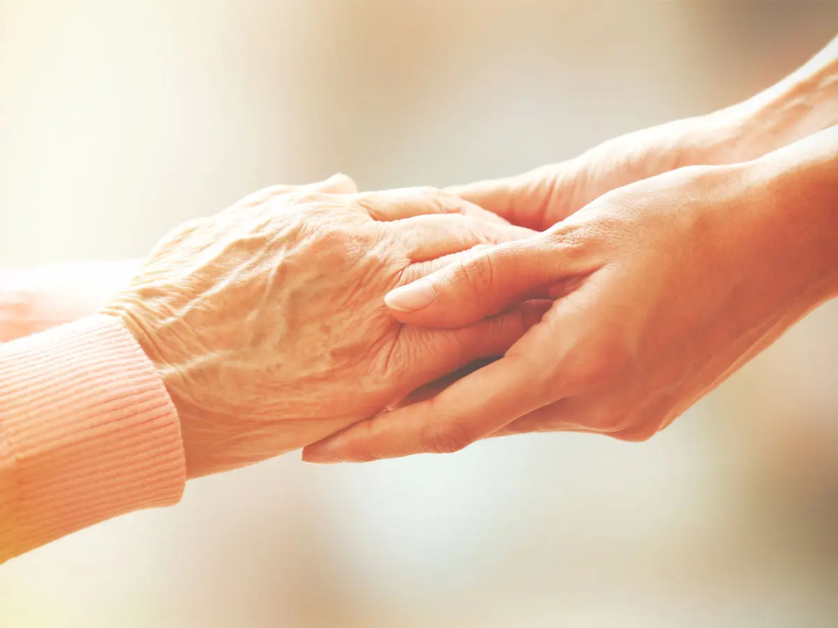 A person holding hands with an older person.